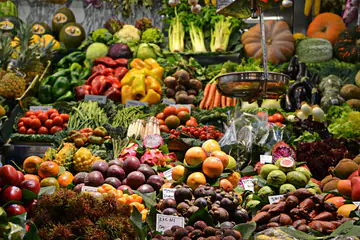 Market stall piled with fruit, peppers, and squash