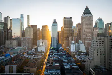 Sunset light down a long avenue between city towers